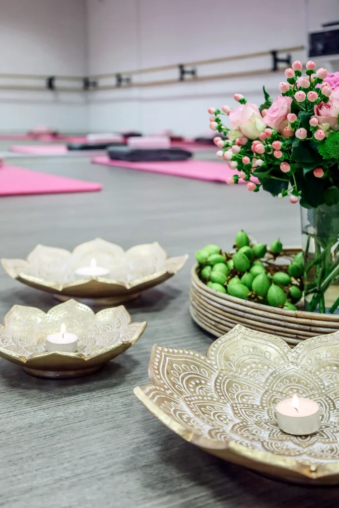 Foto van sfeervol tafereeltje met een boeketje en waxinelichtjes in de yogazaal van Westlandtheater De Naald in Naaldwijk. Op de foto zijn op de achtergrond yogamatten te zien.